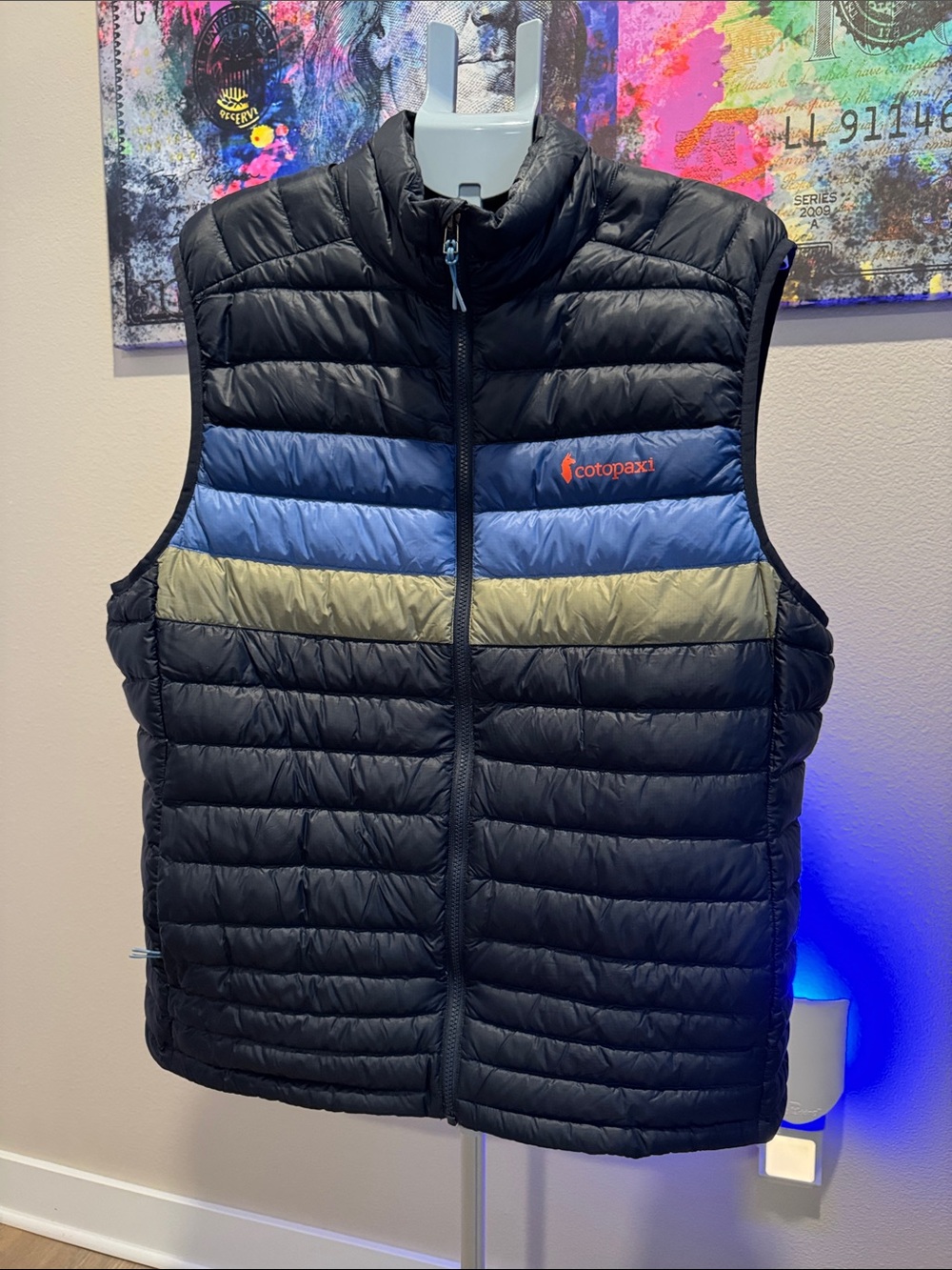 cotopaxi Black Quilted Vest with Blue and Olive Chest Stripes and Orange Logo